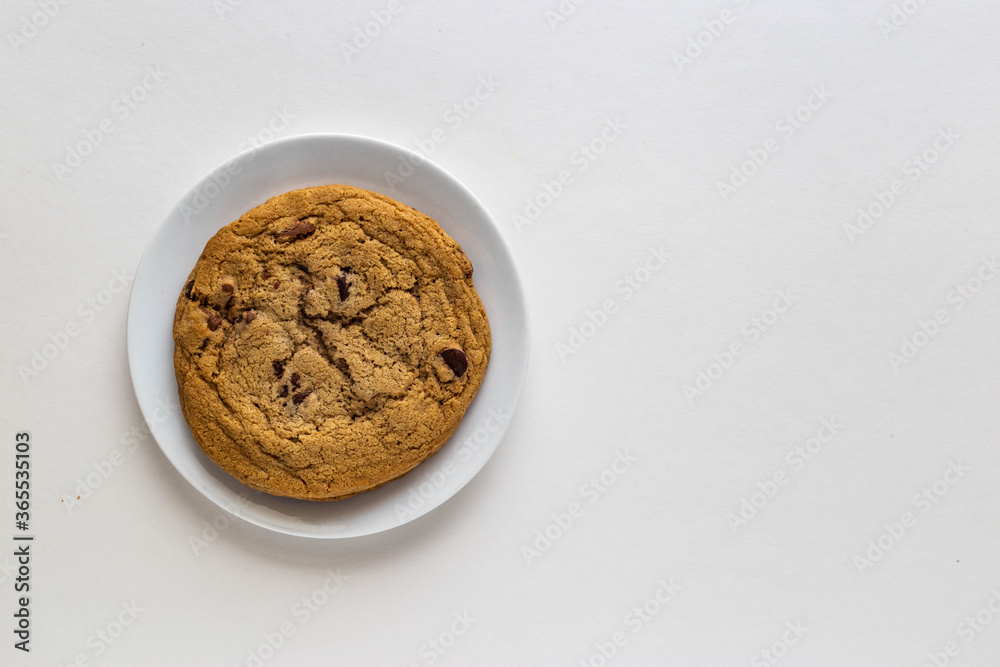 Chocolate chip cookie in white porcelain plate on white background Chocolate chip cookie in white porcelain plate on white background