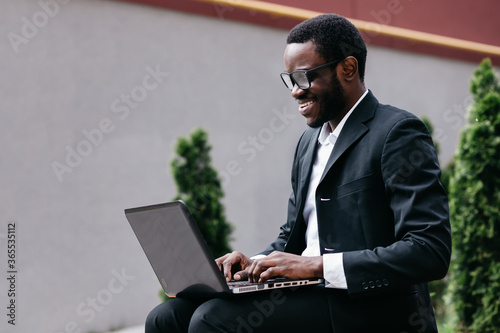 handsome businessman in glasses working on his laptop computer i © Ivan
