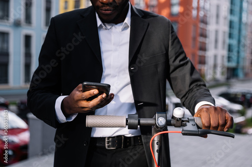 Photography A man holds an electric scooter behind the wheel. Eco-transport
