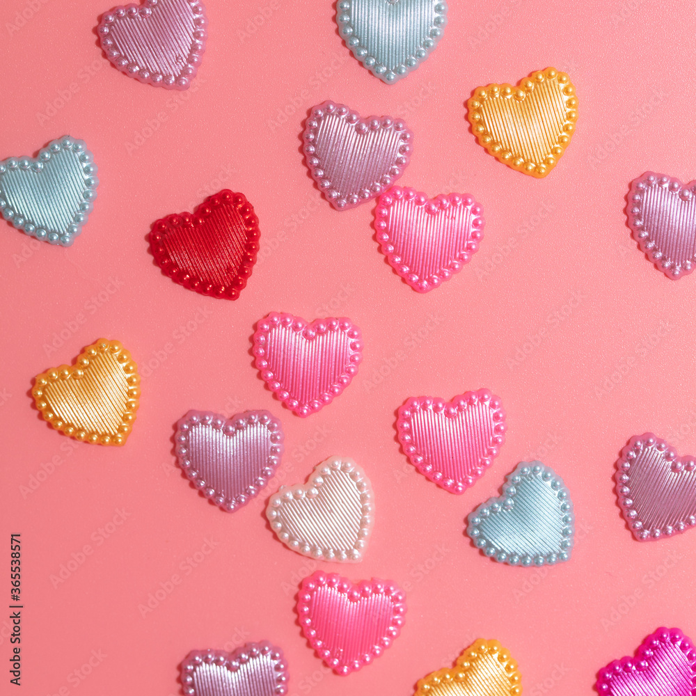 Multi-colored hearts on a pink background.