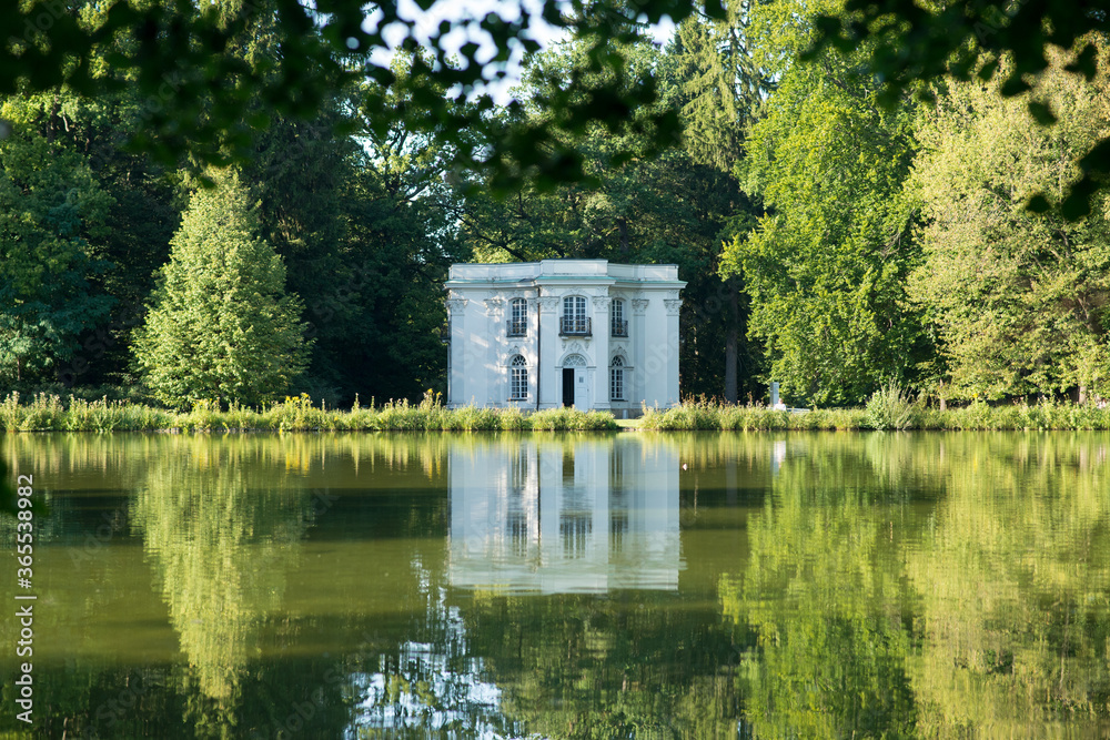 Fototapeta premium Old house on the lake. Reflections of a building in the water on a bright summer day