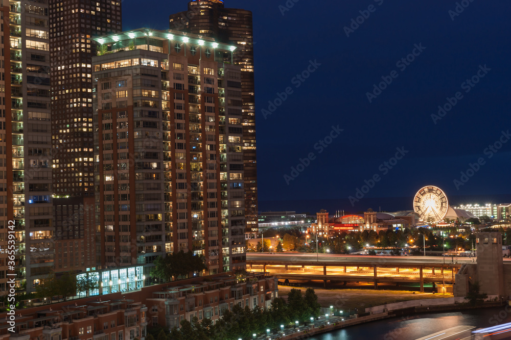 Chicago buildings, overground railway, urban road and lights streams with light flares from street lights, Illinois, USA.