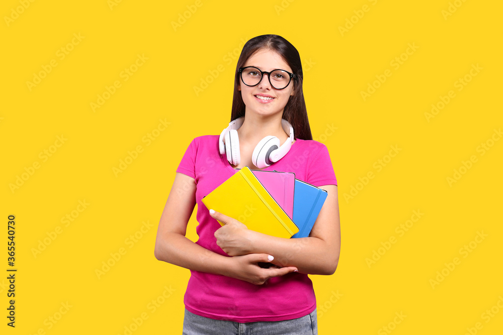 Young beautiful curvaceous woman with headphones posing over bright wall background with a lot of copy space for text. Portrait of attractive female with long brunette hair wearing pink t-shirt. Young beautiful curvaceous woman with headphones posing over bright wall background with a lot of copy space for text. Portrait of attractive female with long brunette hair wearing pink t-shirt.