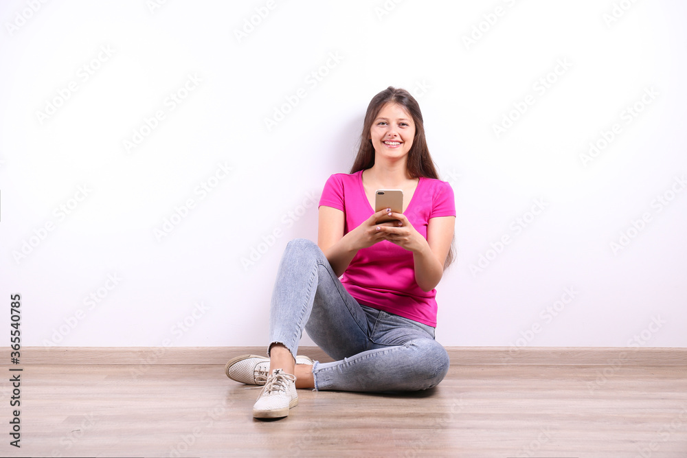 Young beautiful curvaceous woman posing with new phone over isolated background with a lot of copy space for text. Portrait of attractive female with long brunette hair wearing loose pink t-shirt. Young beautiful curvaceous woman posing with new phone over isolated background with a lot of copy space for text. Portrait of attractive female with long brunette hair wearing loose pink t-shirt.