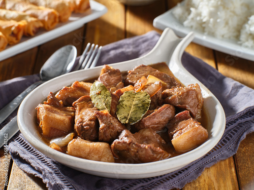 filipino pork adobo in bowl with bay leaves close up photo