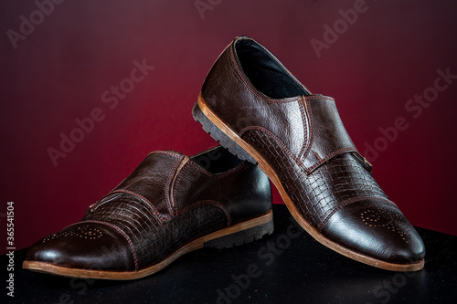 Brown leather men's shoes on red background