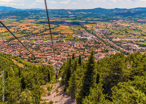 A view down the Colle Eletto cable car from the top of Mount Ingino over the cathedral city of Gubbio, Italy towards the Apennine mountains in summer photo