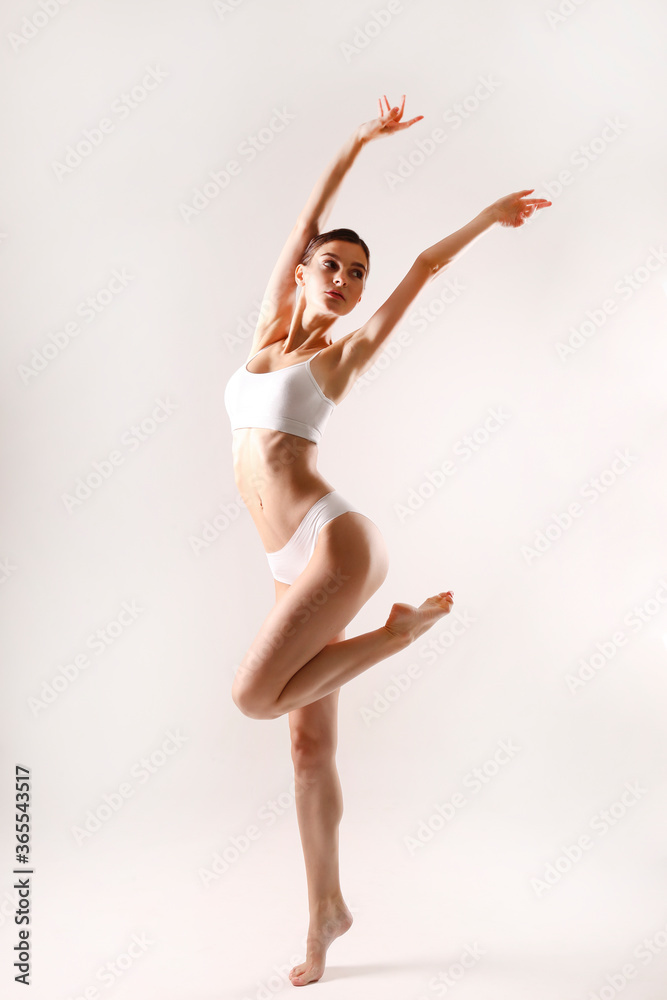 Obraz premium Sporty female in white bra and panties over background.