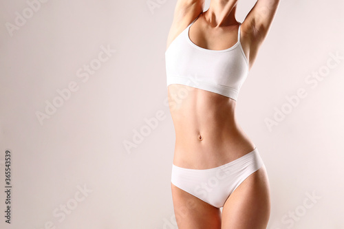 Sporty female in white bra and panties over background. photo