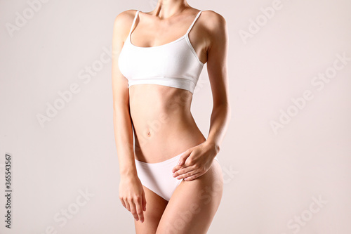 Cropped image of a sporty female in white bra and panties.