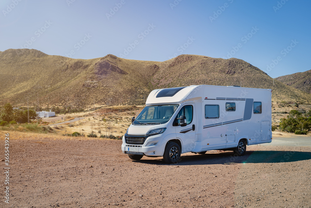 Caravan motor home parked on desertic nature landscape on a sunny day