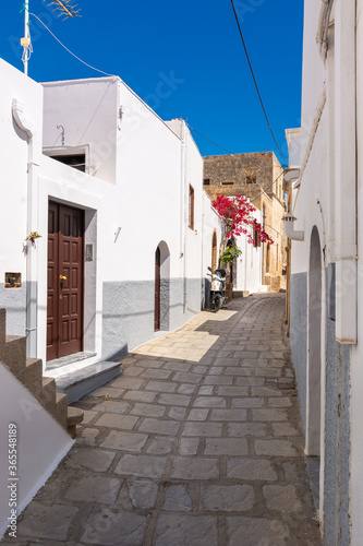 Fototapeta Naklejka Na Ścianę i Meble -  Greek narrow street with white houses on Rhodes island. Lindos village, Dodecanese, Greece.