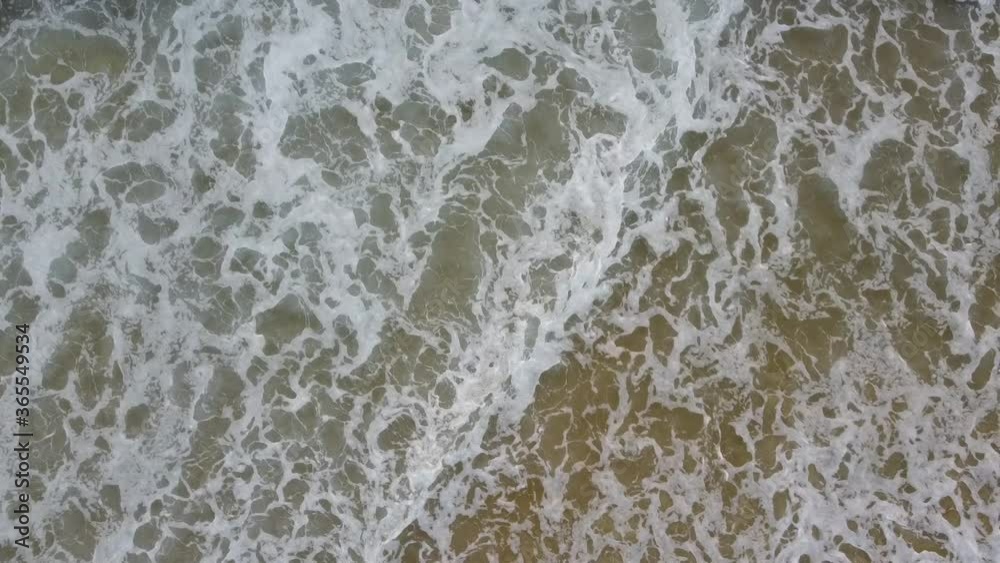 Aerial shot of waves crashing in water with foam Aerial shot of waves crashing in water with foam