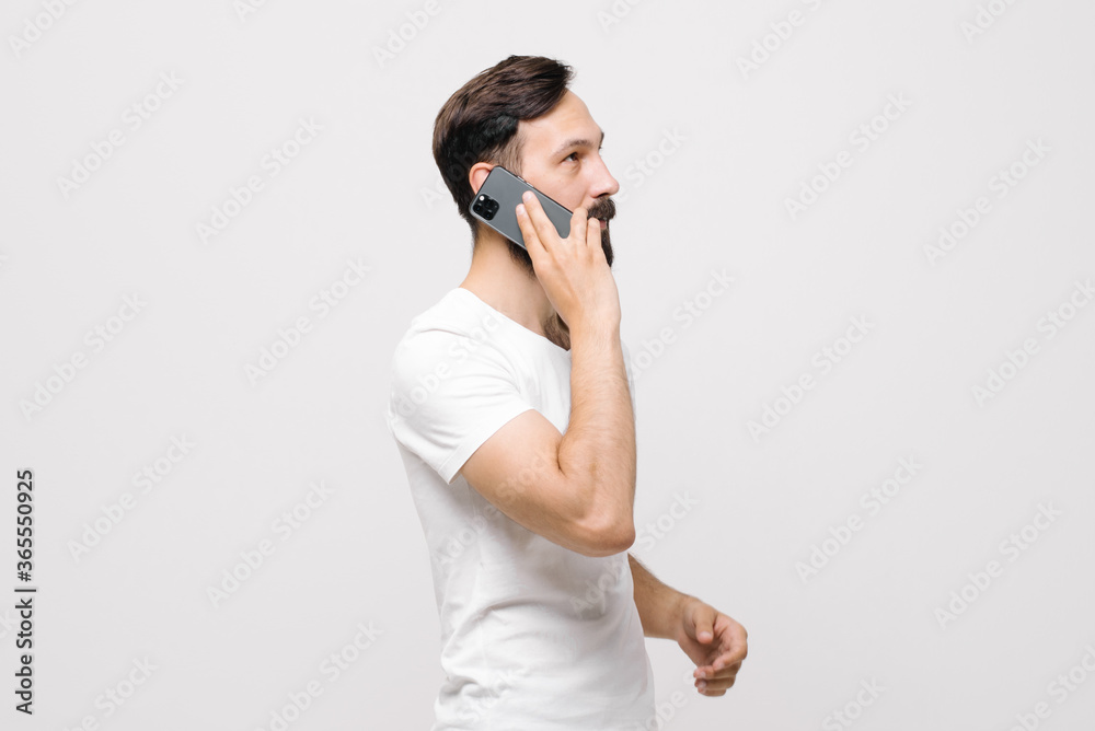 Portrait of happy young man smiling and using cellphone