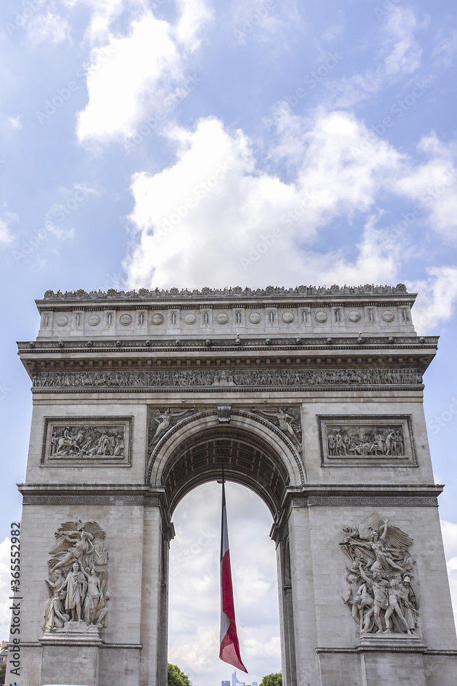 Arc de Triomphe de l'Etoile (1806 - 1836) decorated with the flag of France on French National Day (Bastille Day). Paris, France.