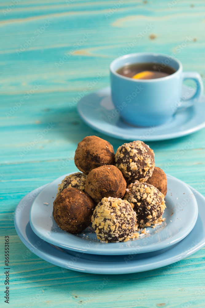 A portion of homemade energy balls and a Cup of tea on a blue wooden table. Delicious, healthy dessert. Lifestyle. Diet. Close up A portion of homemade energy balls and a Cup of tea on a blue wooden table. Delicious, healthy dessert. Lifestyle. Diet. Close up