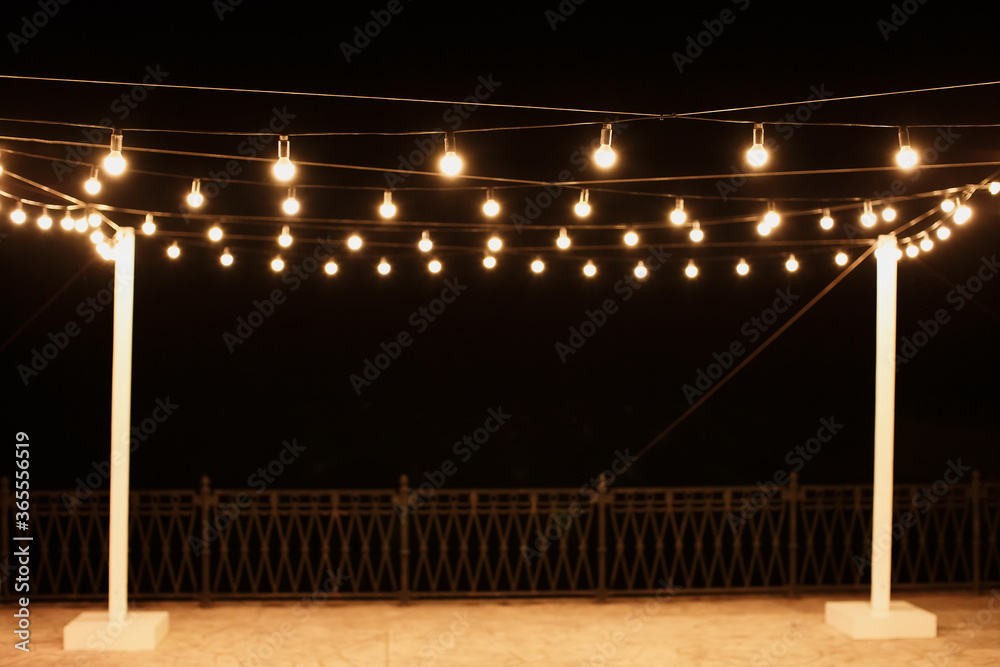 Φωτογραφία Garlands of lamps on a wooden stand on the street