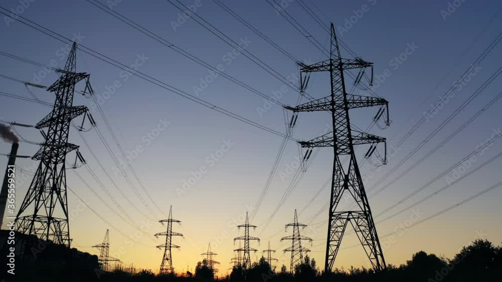 Electricity pylons in the evening.Silhouettes of high voltage power lines against the sunset sky. Transmission towers. Electric high voltage pylons in dusk. Electricity pylons in the evening.Silhouettes of high voltage power lines against the sunset sky. Transmission towers. Electric high voltage pylons in dusk.