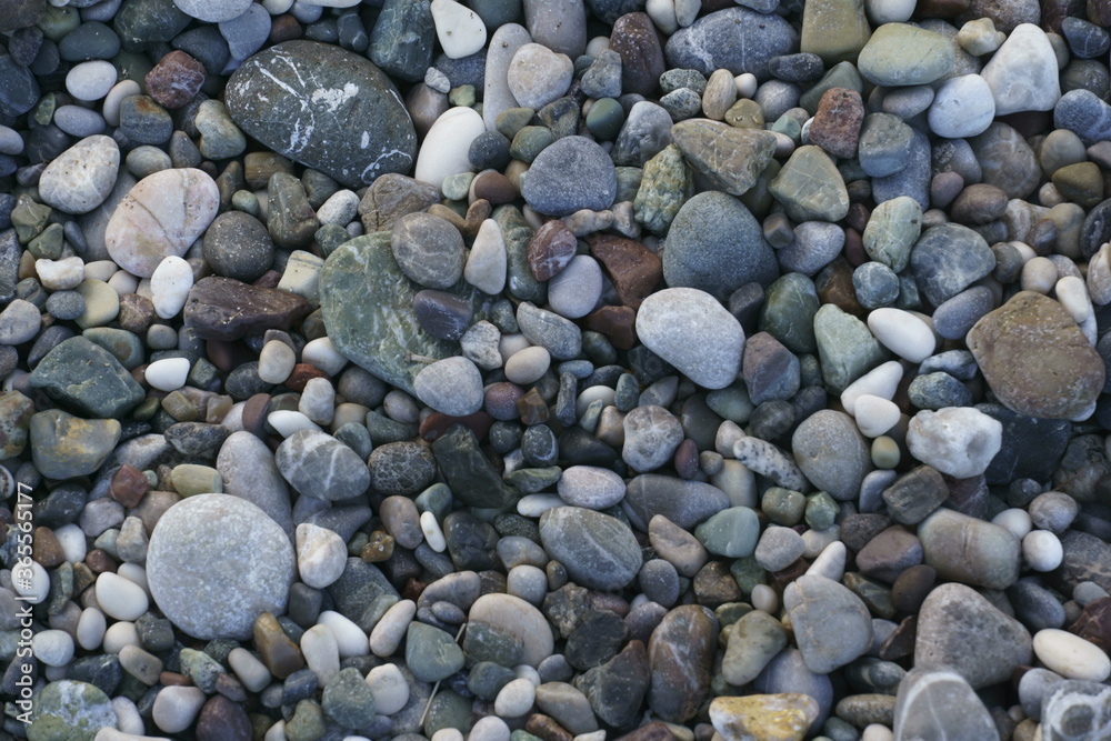Closeup view of small stones on the beach with colorful pattern Closeup view of small stones on the beach with colorful pattern