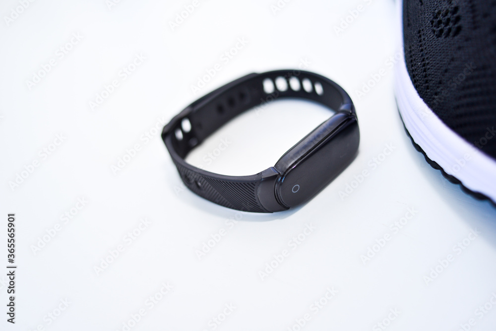 Sports black shoes and watches for monitoring your health on a white background Sports black shoes and watches for monitoring your health on a white background