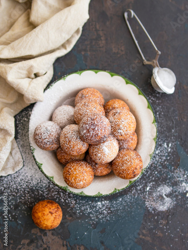 Beautiful breakfast. Cottage cheese donuts balls with sugar powder on a dark background. Close up. Copy space,