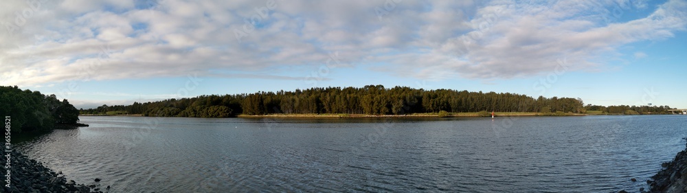Beautiful panoramic view of a calm river with deep blue sky and trees along the river bank, Ermington, Parramatta river, New South Wales, Australia Beautiful panoramic view of a calm river with deep blue sky and trees along the river bank, Ermington, Parramatta river, New South Wales, Australia