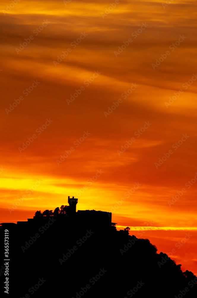 Monte Igueldo de San Sebastian a contra luz en un atardecer anaranjado. 
