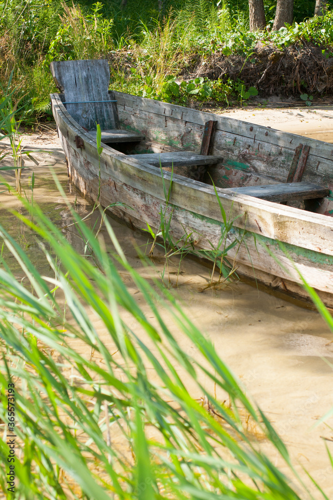 Old boat on the lake on a sunny day and reeds Old boat on the lake on a sunny day and reeds