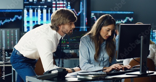 Portrait of traders and brokers working at stock exchange office. Monitors Display Relevant Infographics, Data and Numbers. Global Financial Concept