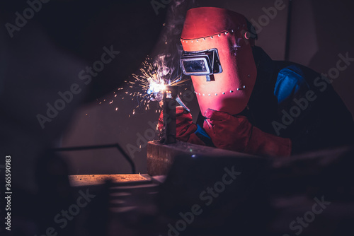 Metal welding steel works using electric arc welding machine to weld steel at factory. Metalwork manufacturing and construction maintenance service by manual skill labor concept. photo