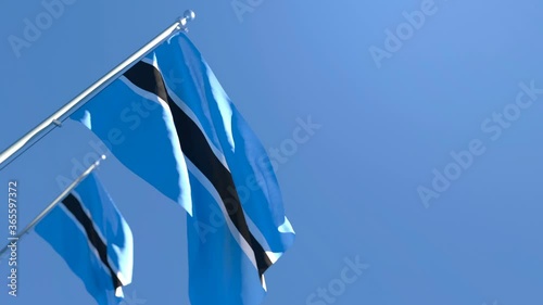 The national flag of Botswana is flying in the wind against a blue sky photo