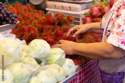 female vendor's hands arranging the fresh fruit for sale at the market