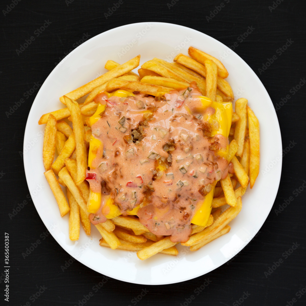 Φωτογραφία Homemade Animal Style French Fries on a white plate on a black surface, top view