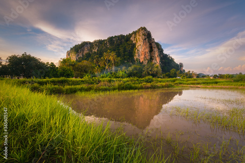 beautiful reflection of the famed historical Keriang Hill with paddy rice field on foreground minutes before sunset. Keriang Hill is located near Alor Setar, the capitalcity of Kedah. photo