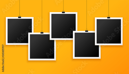 five hanging photo frames on yellow background photo