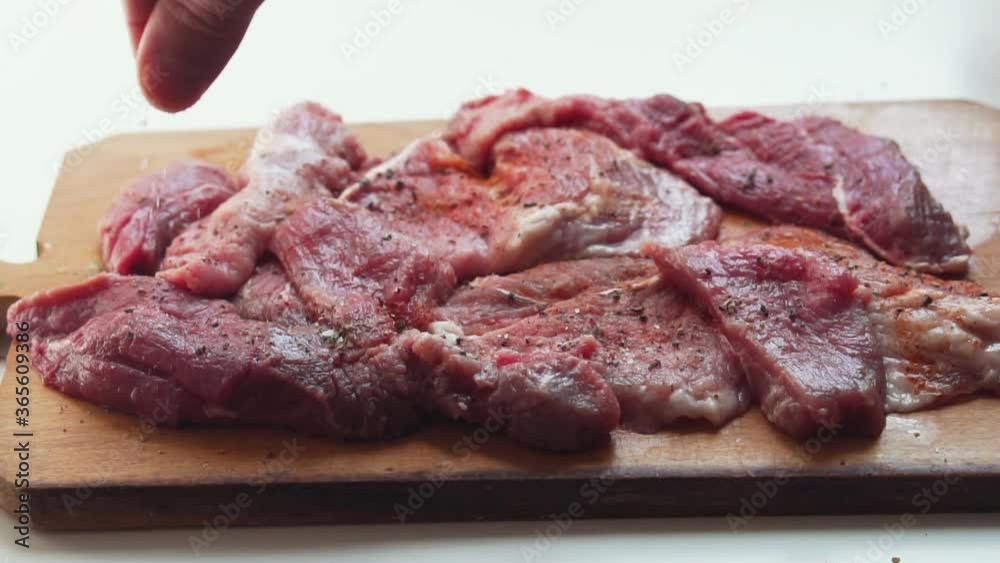 Chef accompanying raw meat with salt. Chef accompanying raw meat with salt.