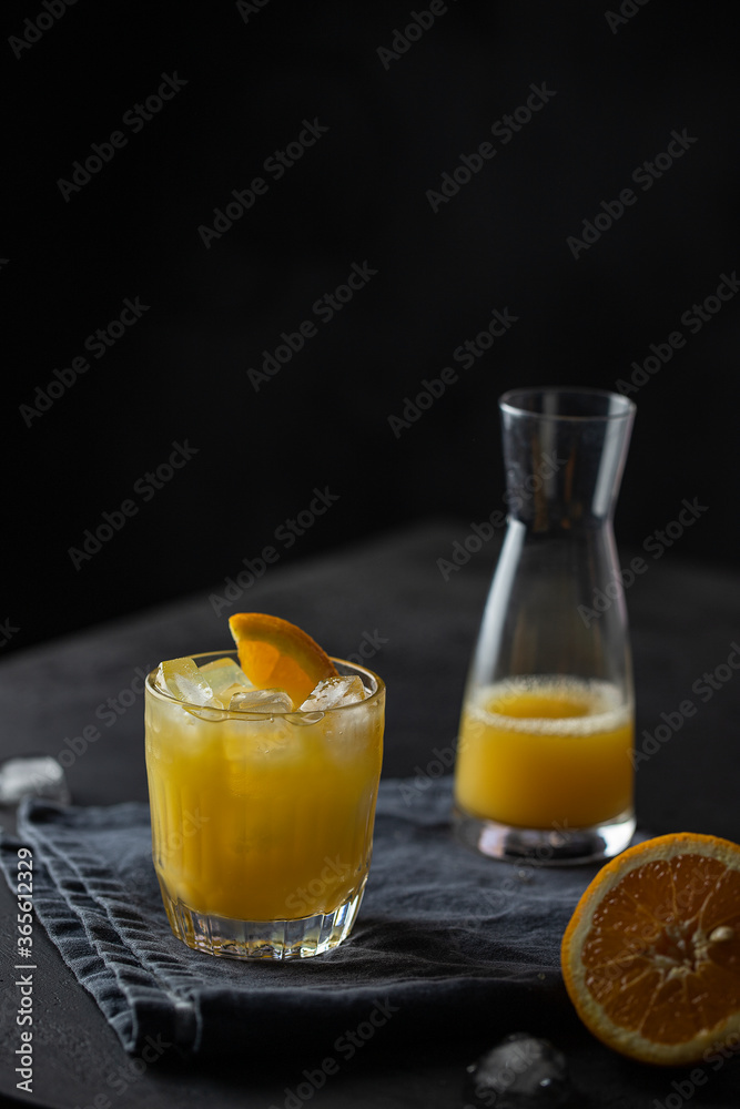 Orange juice glass with ice on dark background. Refreshment cold drink . Orange juice glass with ice on dark background. Refreshment cold drink .