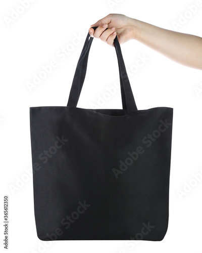 Blank tote bag mock up, isolated on white background, Front view. Empty black cotton tote bag template for shopping. Clear canvas tote bag for grocery. Girl carry reusable eco hand bag for branding. © Heymrpatrick