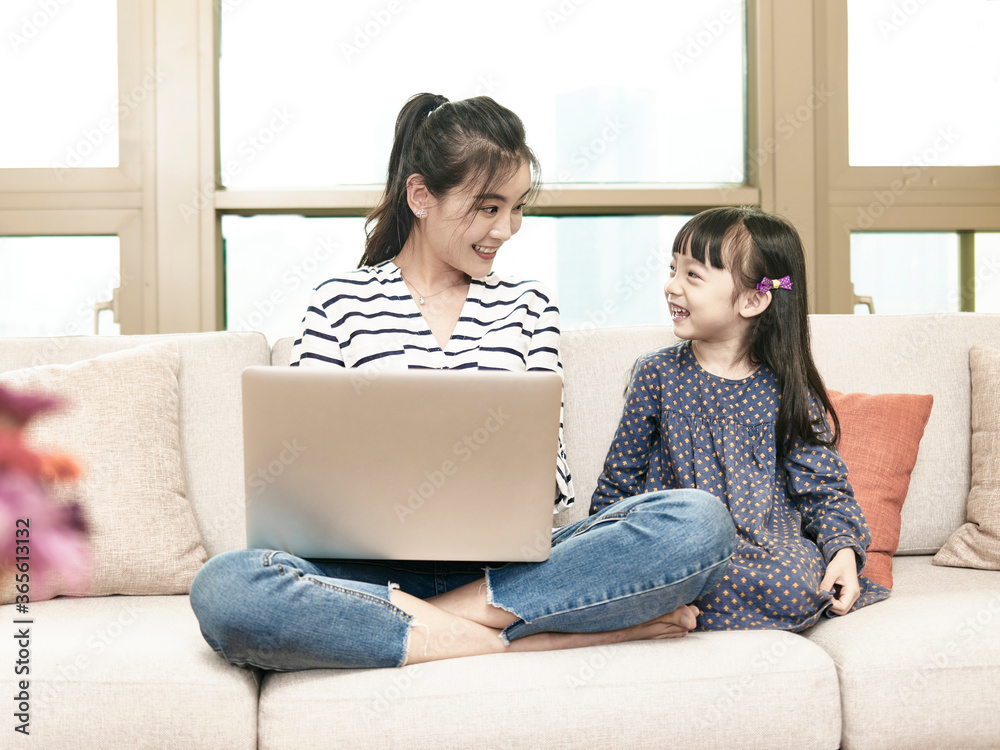 young asian woman working from home while taking care of daughter young asian woman working from home while taking care of daughter
