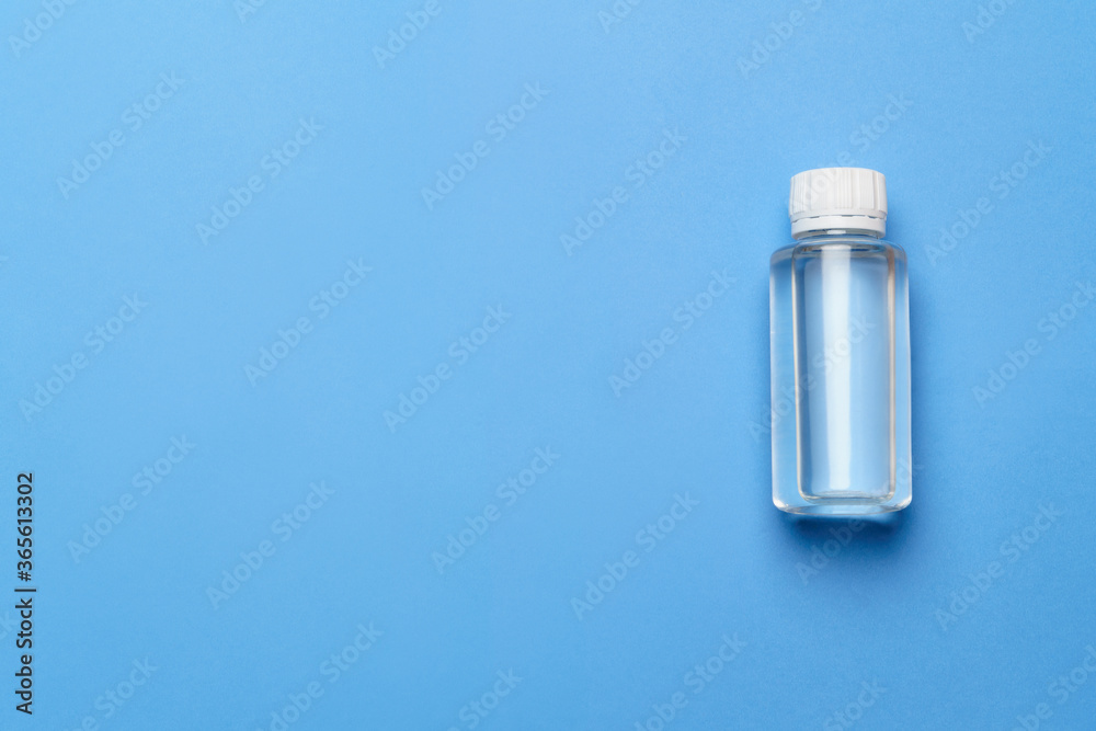 Bottle of antiseptic alcohol hand sanitize spray on a blue background for the prevention of coronavirus - flat layout with copy space Bottle of antiseptic alcohol hand sanitize spray on a blue background for the prevention of coronavirus - flat layout with copy space