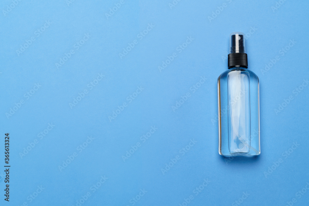 Naklejka premium Bottle of antiseptic alcohol hand sanitize spray on a blue background for the prevention of coronavirus - flat layout with copy space