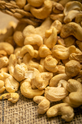 A pile of cashew nuts on burlap with a rough texture surface texture. Close up.