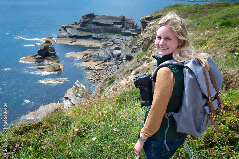 Blond woman with camera exploring the coast of France brittany at Îlot des Capucins near Roscanvel