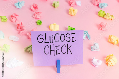 Handwriting text writing Glucose Check. Conceptual photo a procedure that measures the amount of sugar in the blood Colored crumpled papers empty reminder pink floor background clothespin © Artur