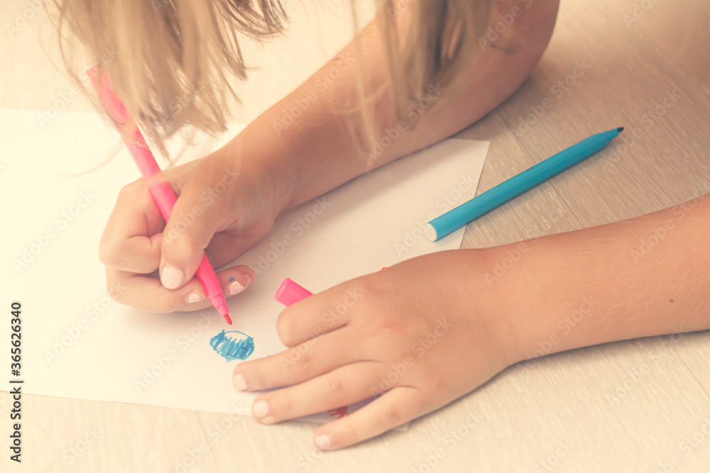 Favorite activity of the child. A happy family. The girl draws with colored markers. Girl's hands. Favorite activity of the child. A happy family. The girl draws with colored markers. Girl's hands.