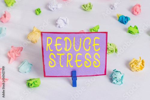 Writing note showing Reduce Stress. Business concept for to lessen the state of mental or emotional strain or tension Colored crumpled paper empty reminder white floor clothespin photo