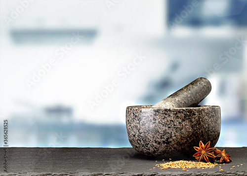 granite mortar and spices on table in front of blurred kitchen
