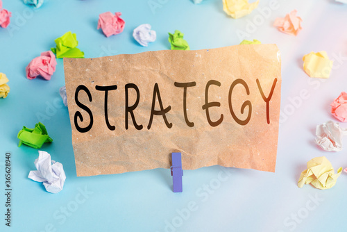 Text sign showing Strategy. Business photo text action plan or strategy designed to achieve an overall goal Colored crumpled papers empty reminder blue floor background clothespin photo