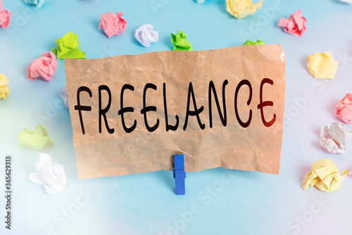 Text sign showing Freelance. Business photo text working at different firms rather than being permanently Colored crumpled papers empty reminder blue floor background clothespin photo