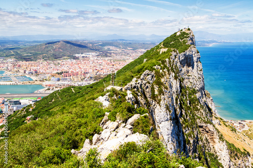 Aerial view of top of Gibraltar Rock, in Upper Rock Natural Reserve: on the left Gibraltar town and bay, La Linea town in Spain at the far end, Mediterranean Sea on the right. United Kingdom, Europe.